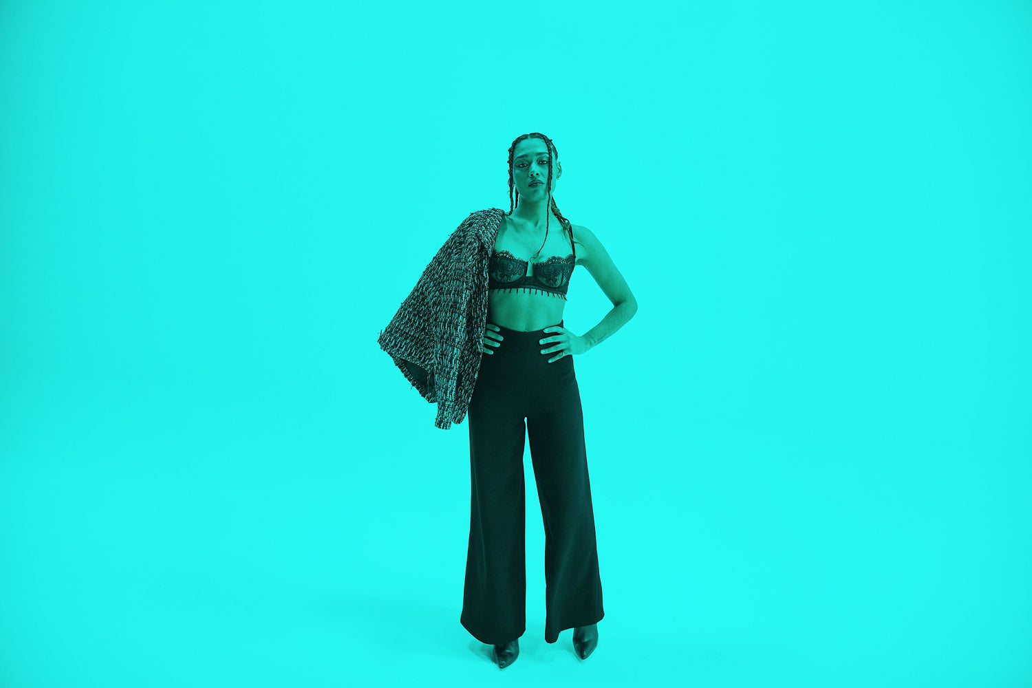 woman in black bands and black lace bra, teal blue background