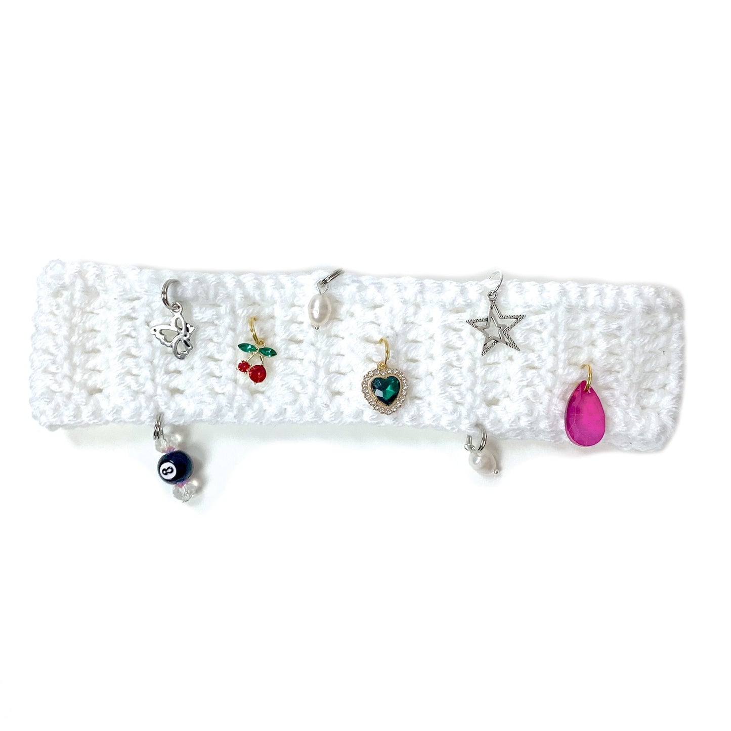 White crochet headband with decorative charms adorning the headband