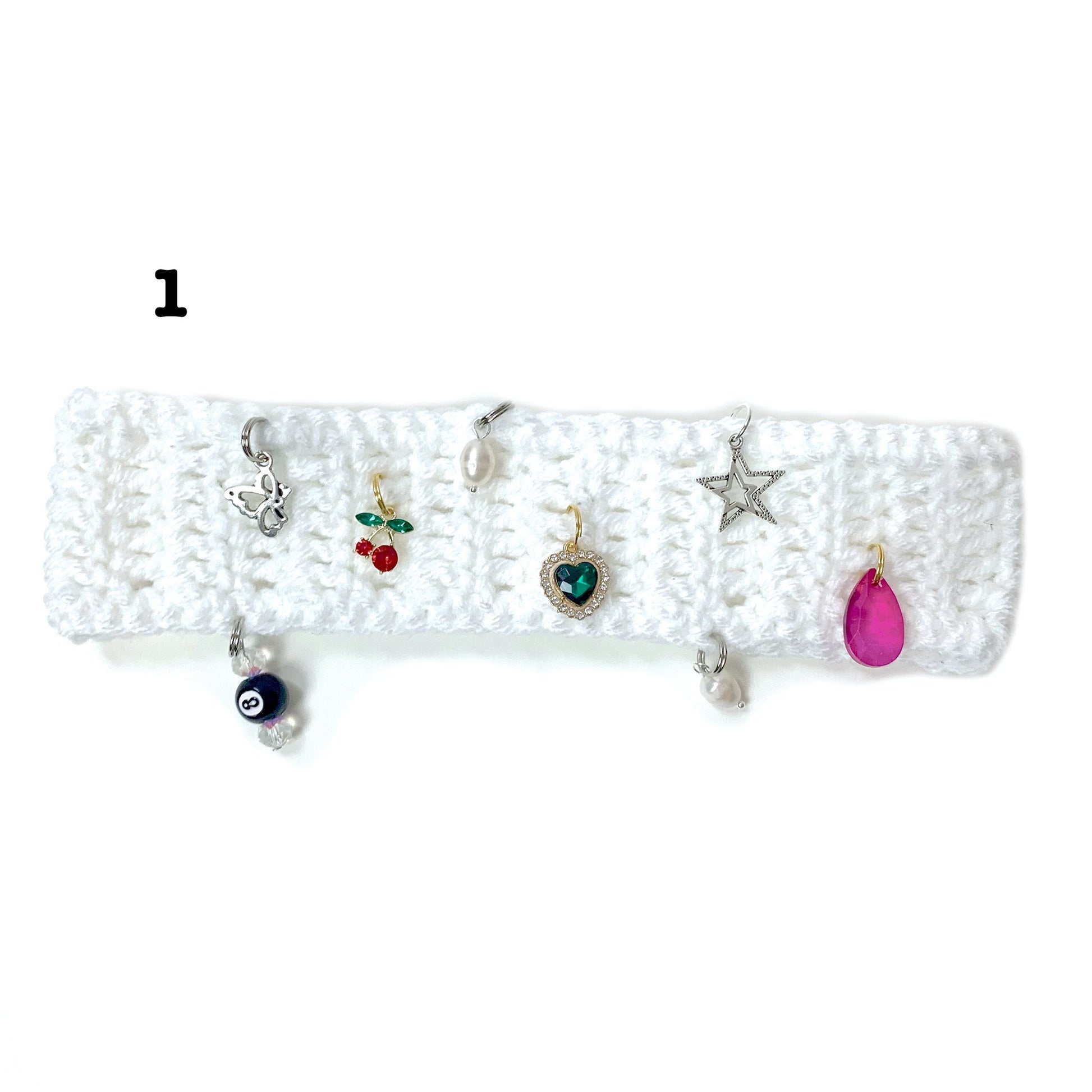 White crochet headband with decorative charms adorning the headband